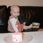 Eliisa ser granskende på kaka. Rosa og fin… som jenta selv er det på sin egen fødselsdag.